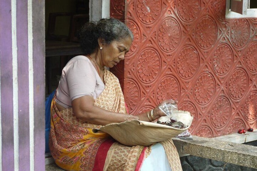 A person sitting on a ledge, holding a basket with food items. 3
