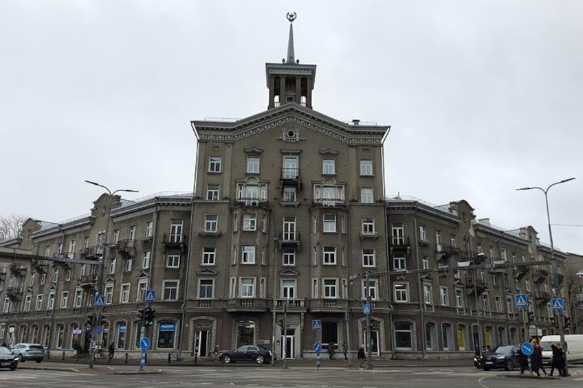 Ein großes, historisches Gebäude mit mehreren Stockwerken und einem zentralen Turm. 2