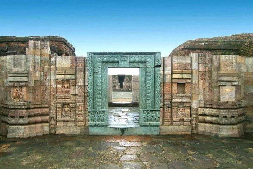 An ancient stone gateway with intricate carvings, leading into a structure. 3
