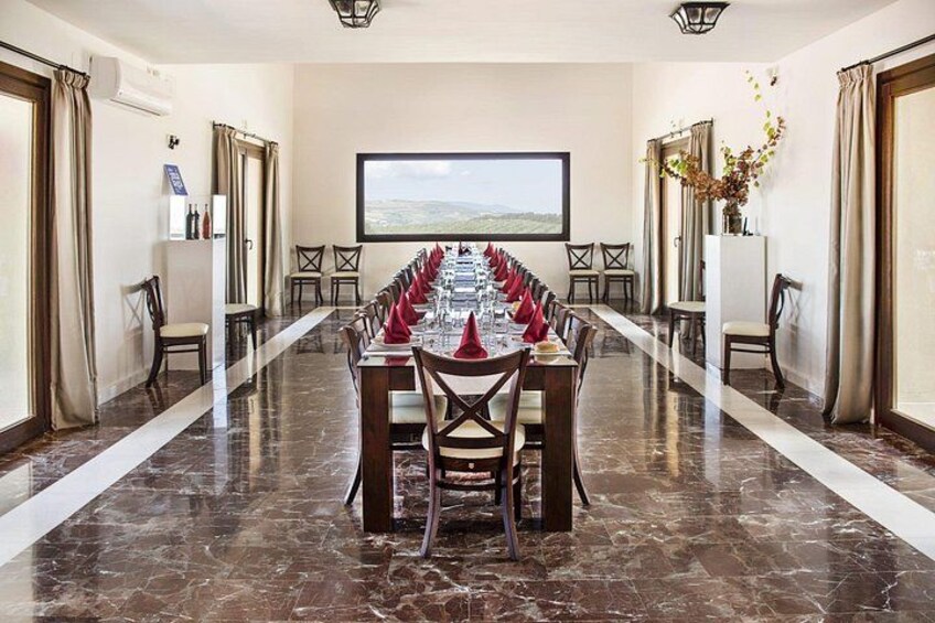 Une salle de conférence avec une longue table préparée pour une réunion, un grand écran et une vue sur l’extérieur. 5
