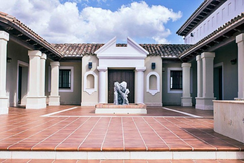 Une cour ornée d’une statue, dotée d’un sol carrelé et présentant une architecture classique. 4