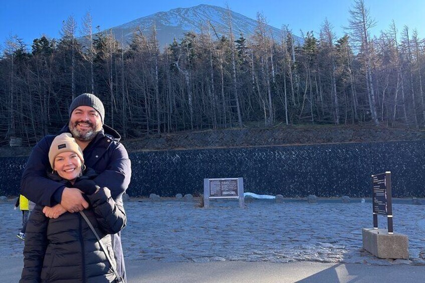 A person embracing another in a snowy landscape with a mountain in the background. 1