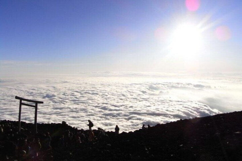 A mountain peak with a wooden structure, possibly a viewing platform, and a vast sea of clouds below. 5