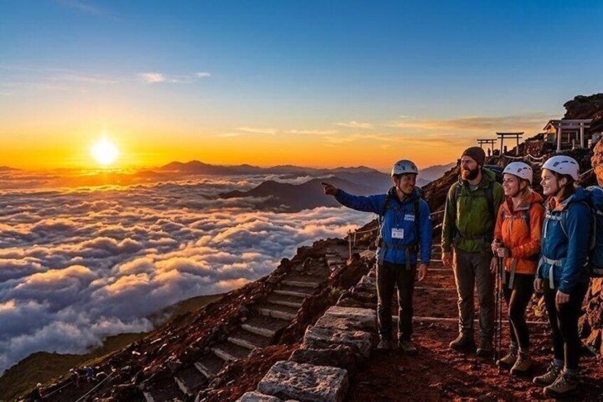 A group of hikers on a mountain trail with a sunrise in the background. 1