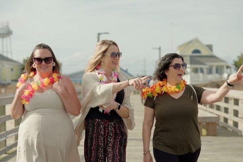 Three people walking on a pier, wearing leis. 2