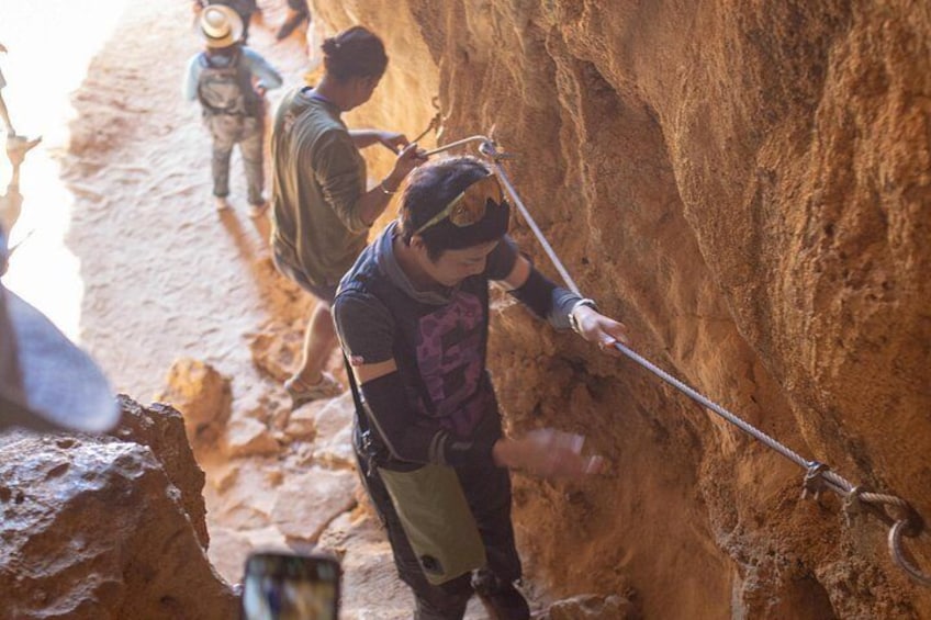 A person rappelling down a rocky cliff. 4