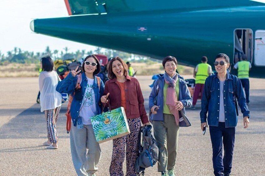 People walking on a tarmac with an airplane in the background. 3