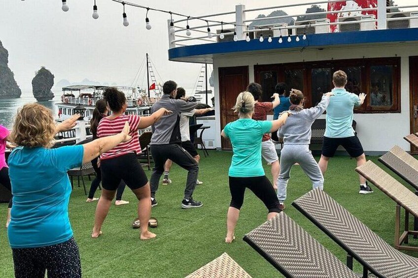 A group of people exercising on a deck with a boat in the background. 5