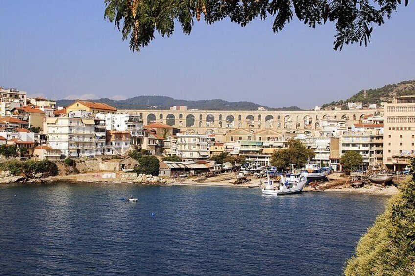 A coastal town with buildings, boats, and a bridge. 3