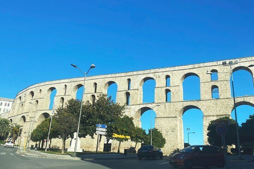 A large, historic stone structure with multiple arches and a blue door. 2