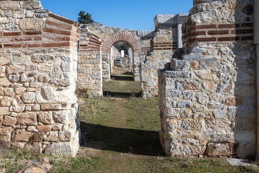 An ancient stone structure with arched passageways and ruins. 5