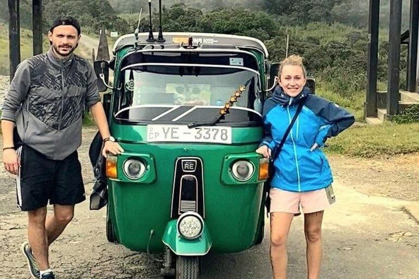 A green vehicle with a license plate YE-3378, two people standing beside it, and a natural landscape in the background. 3