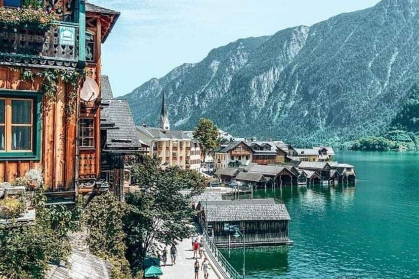 Un village au bord d’un lac, avec des maisons en bois, une église et des montagnes en arrière-plan. 3