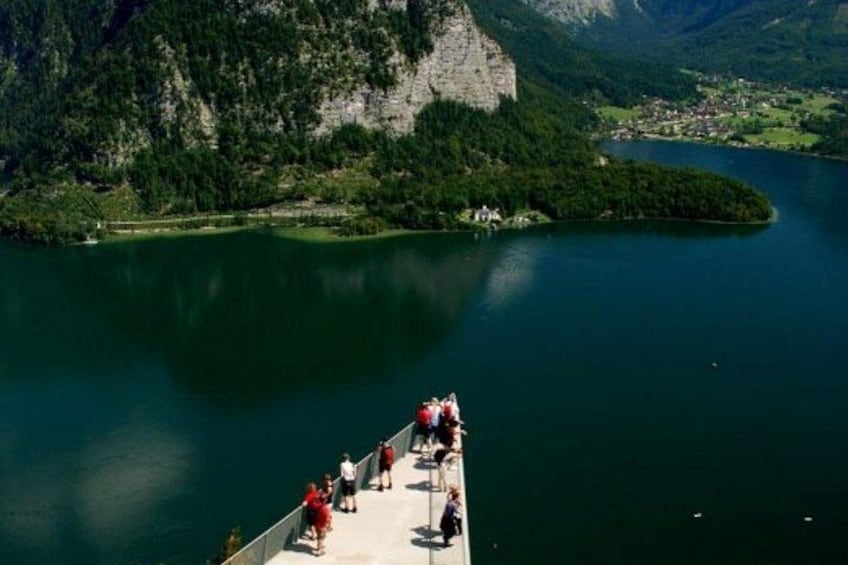 Un lac bordé d’une falaise rocheuse et doté d’une plateforme d’observation où se trouvent des personnes. 2