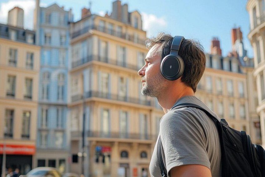 A person wearing headphones, standing on a street with buildings in the background. 4