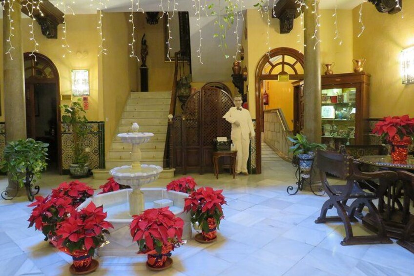 A lobby with a fountain, potted plants, and a staircase. 3