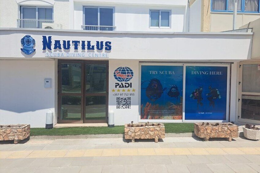 A building named Nautilus Scuba Diving Centre with a PADI logo and two posters advertising scuba diving. 2