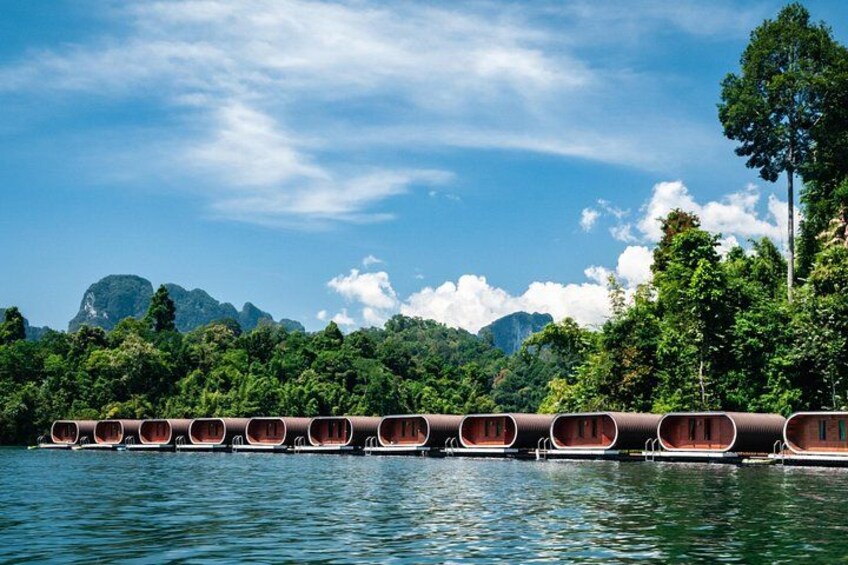 A row of traditional boats on a calm river, surrounded by lush greenery and mountains in the background. 5