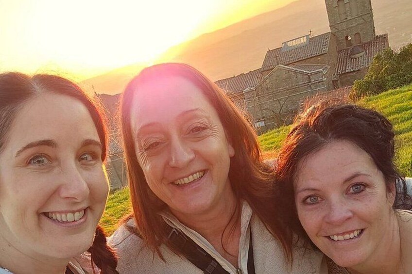 Tres personas frente a una iglesia con un atardecer de fondo. 5