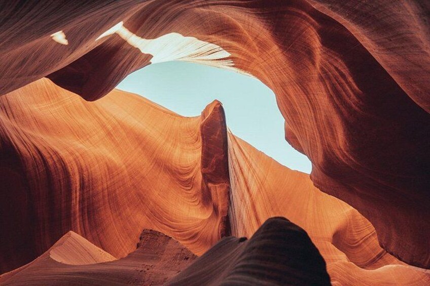 A canyon with smooth, curved sandstone walls and a clear sky. 5