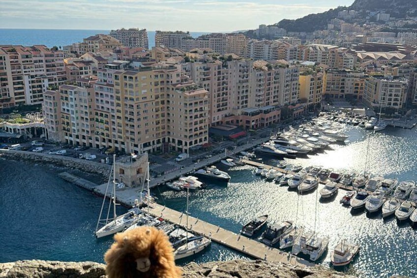 Un paisaje urbano costero con un puerto deportivo lleno de barcos, edificios altos y una costa rocosa. 5