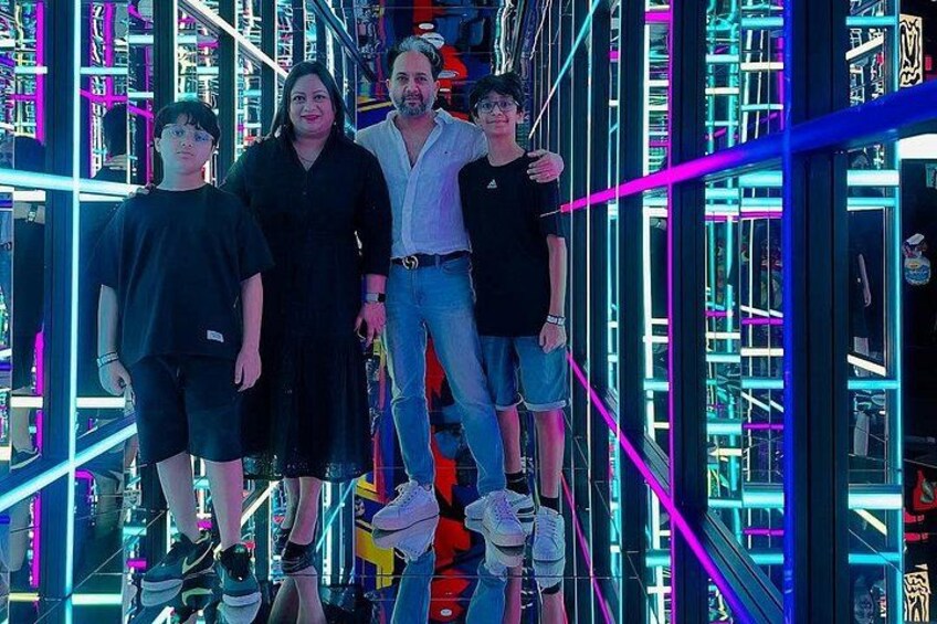 A group of people standing in a brightly lit, neon-lit corridor with vertical lines and shelves. 2