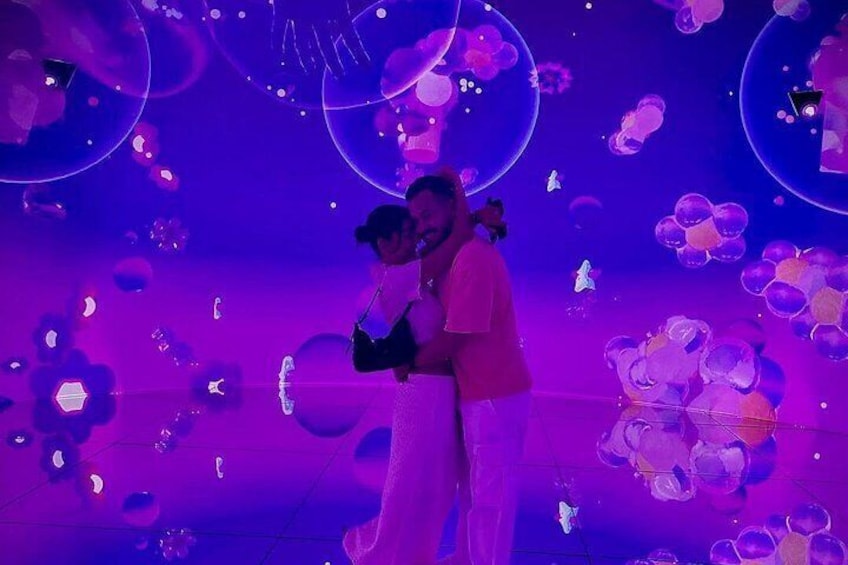 A couple embracing in a room with a purple and blue color scheme and floating bubbles. 4