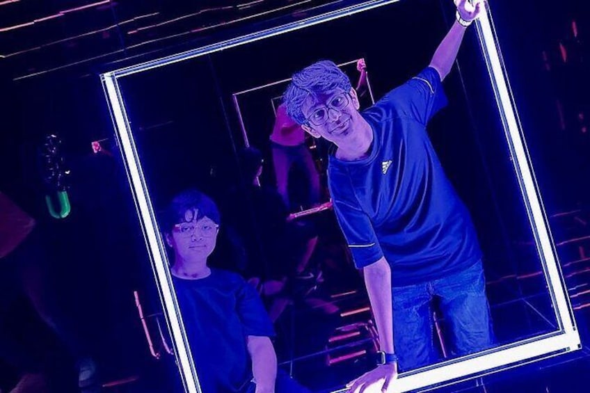 A person holding a large mirror with a reflection of another individual. 2