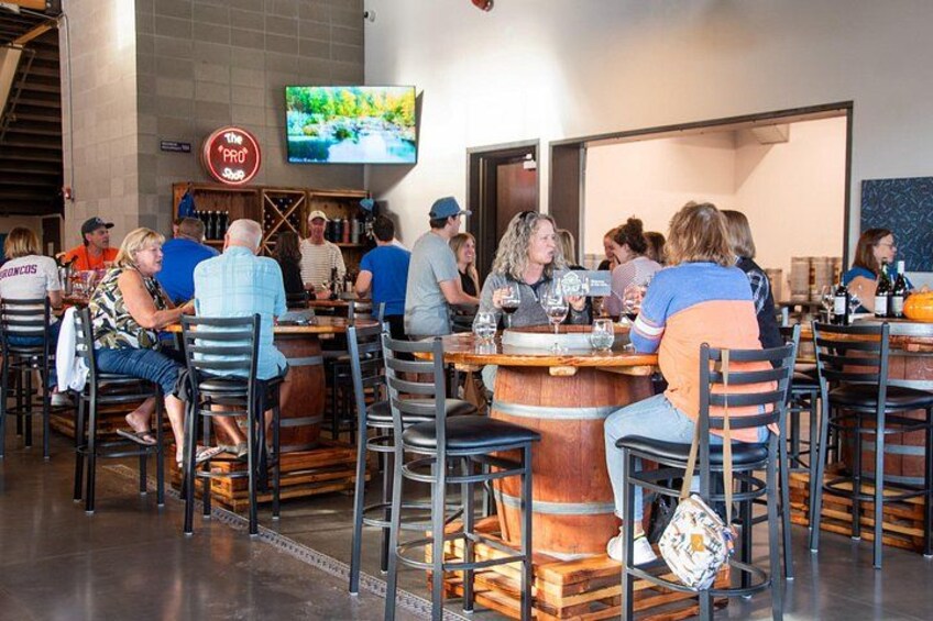 A restaurant with patrons seated at tables, a television mounted on the wall, and a bar area in the background. 5