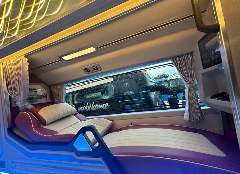 A train interior with a bed, curtains, and a window with 'mobilhome' written on it. 2