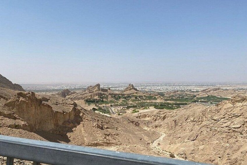 A desert landscape with rocky terrain and distant city views. 3