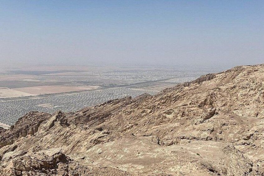A rocky terrain with a distant cityscape. 2