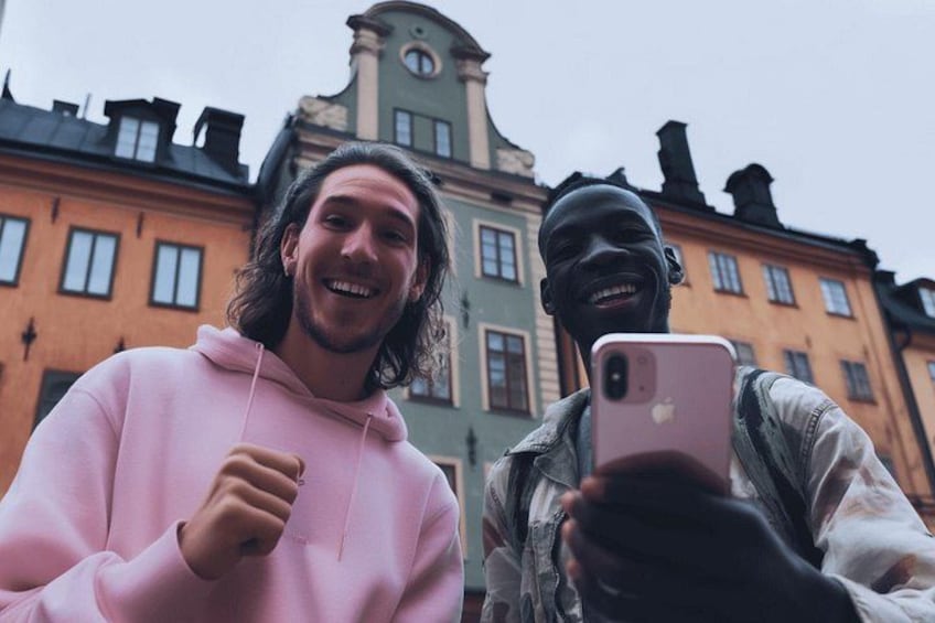 Dos personas tomándose un selfie con un edificio histórico de fondo. 2