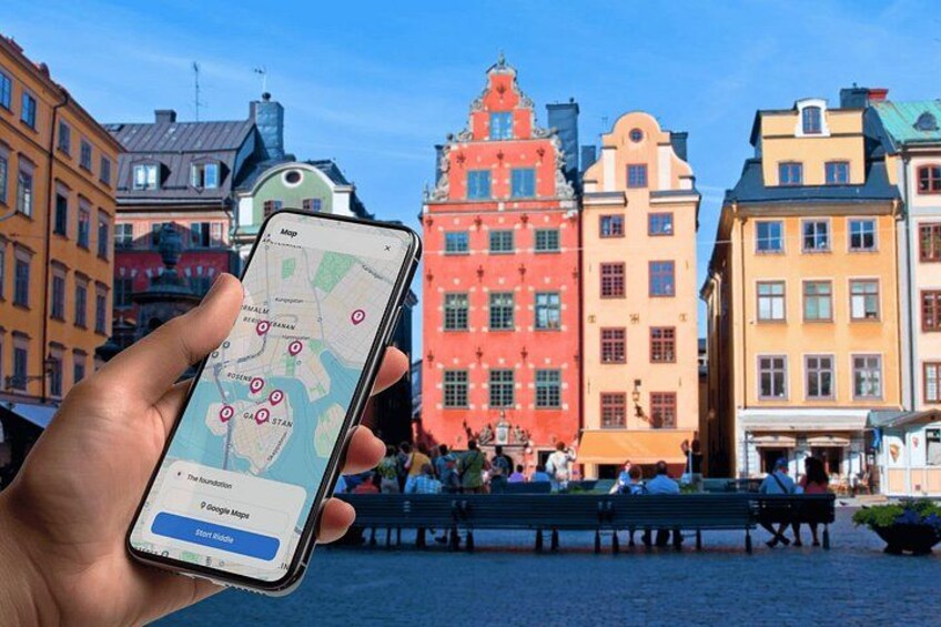 Una mano sosteniendo un teléfono inteligente que muestra un mapa con marcadores de ubicación, y edificios coloridos al fondo. 4