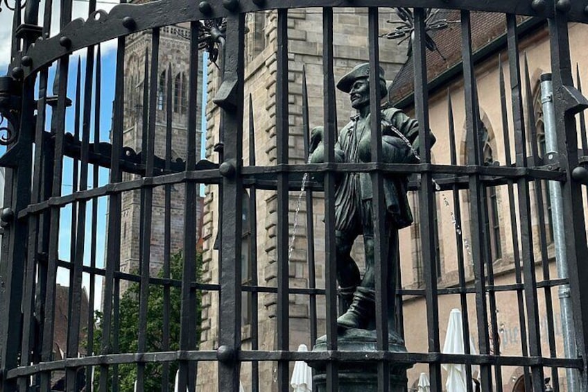 En staty bakom ett staket av metall, med en byggnad i bakgrunden. 3
