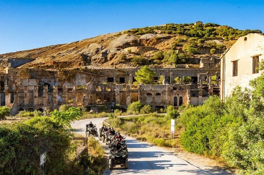A historical site with ruins, a road, and a hill. 1