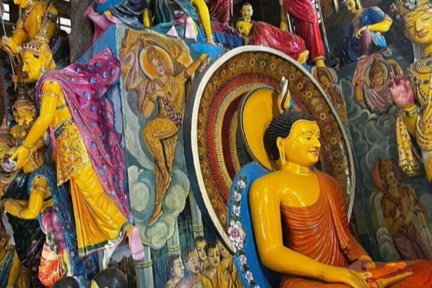 Una estatua de Buda rodeada de estatuas y murales coloridos. 4