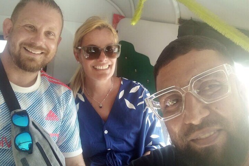 Il y a trois personnes dans le véhicule : l’une porte une chemise bleue à motifs, une autre porte une chemise rayée et la troisième porte une chemise foncée. 3