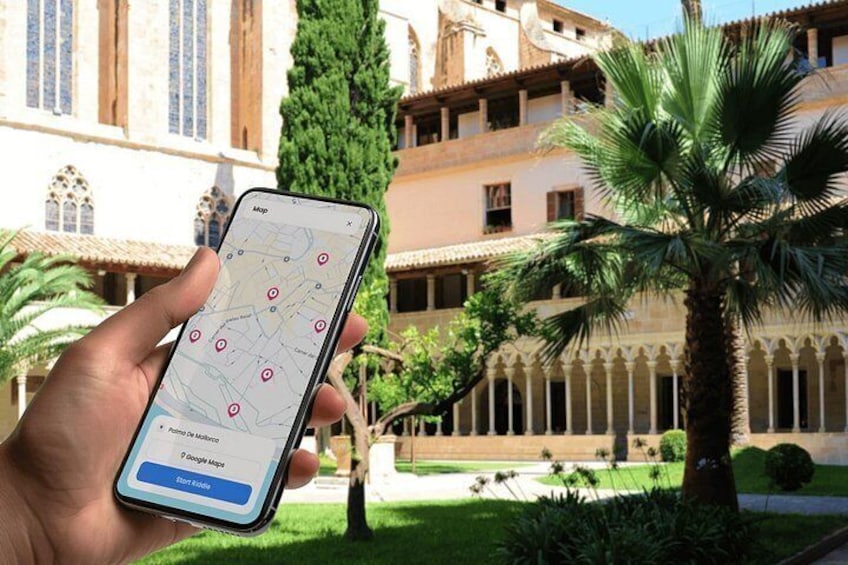A hand holding a smartphone with a map application, palm trees, and a building with arches in the background. 4