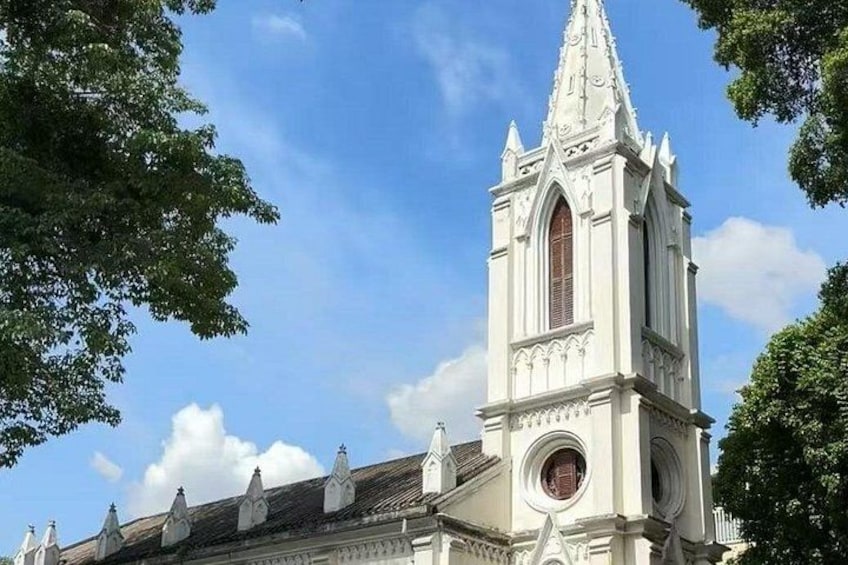A church with a tall spire and a large circular window. 2