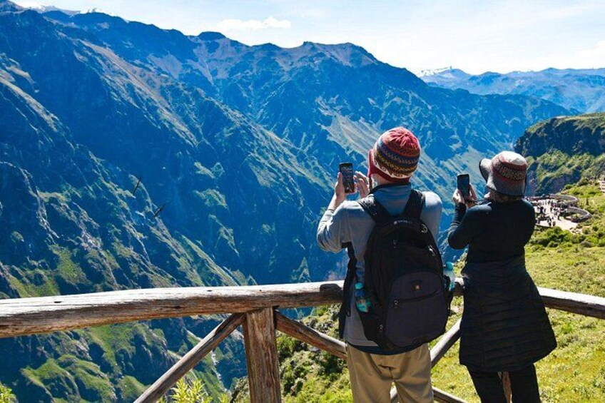 Two people taking photos of a mountainous landscape. 2