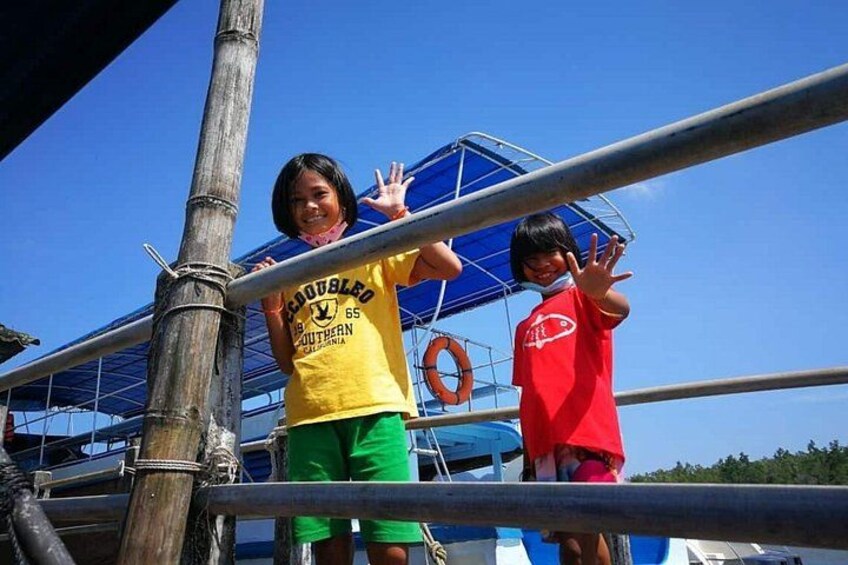 Two children standing on a metal structure with a lifebuoy in the background. 2