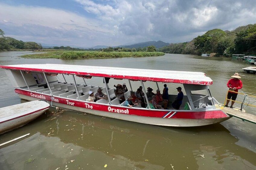 Un bateau transportant des passagers, un quai et une rivière. 1