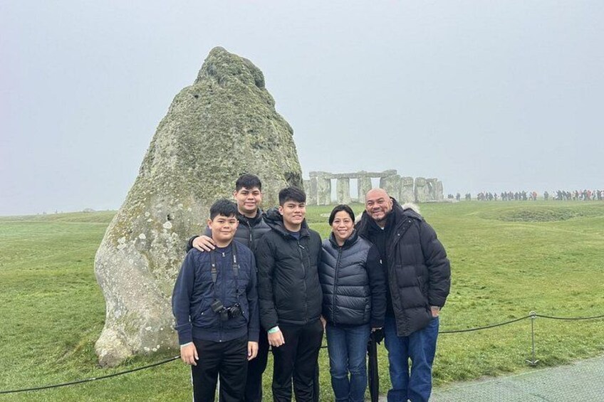 Een groep mensen staat voor Stonehenge. 1