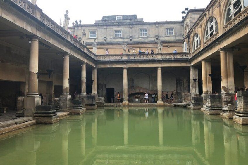 Une cour historique avec une piscine centrale, des colonnes et un bâtiment en arrière-plan. 4