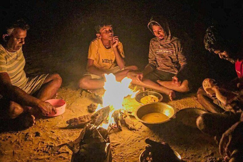 Un groupe de personnes assises autour d’un feu de camp, la nuit. 5