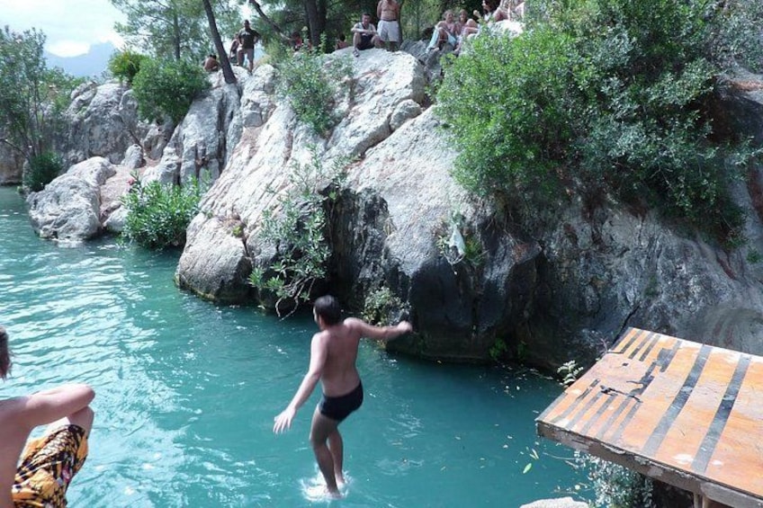 Una persona saltando desde un risco hacia el agua. 1