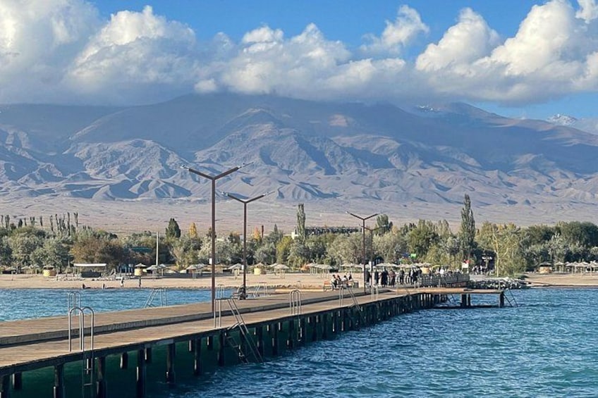 A pier extending into a body of water with mountains in the background. 4