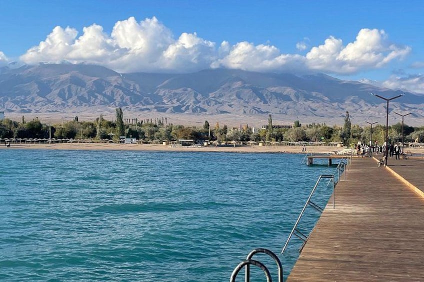 A wooden pier extending into a body of water with mountains in the background. 5