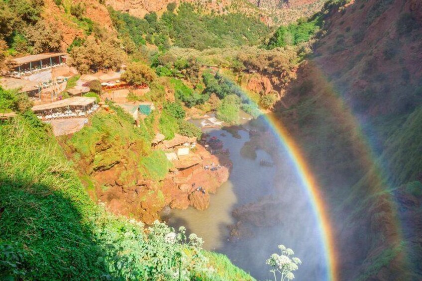 A river, a rainbow, and a mountainous landscape with buildings. 5